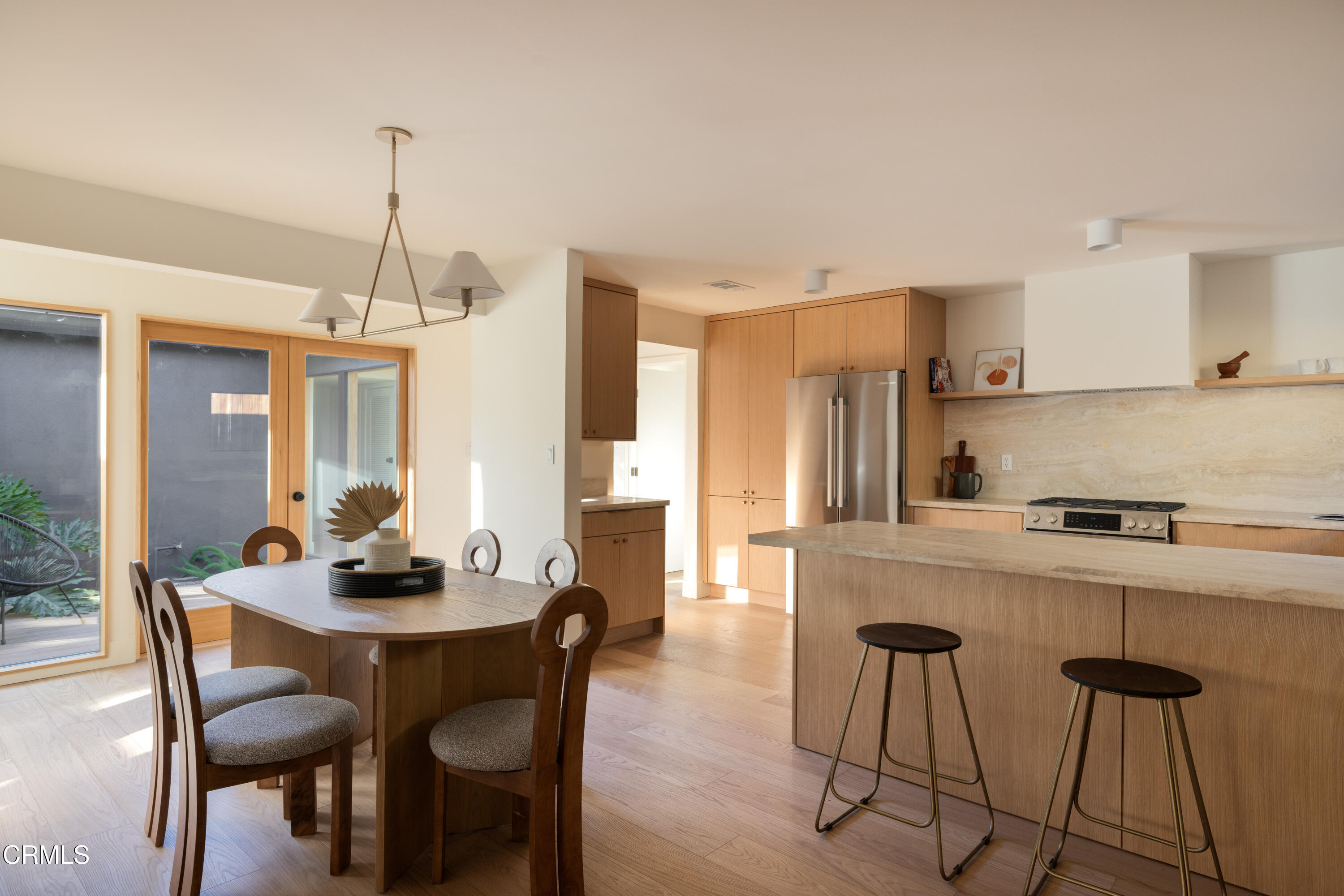 1054 Rutland Avenue Los Angeles, CA 90042 - Photo 10 of 27 a kitchen with stainless steel appliances a dining table chairs and white cabinets
