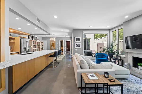 a living room with furniture a flat screen tv and a large window