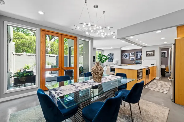 a outdoor dining room with furniture a chandelier and window