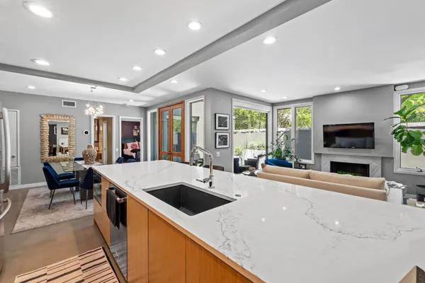 a large living room with stainless steel appliances granite countertop a sink a stove and a refrigerator