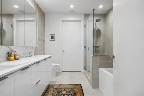 a bathroom with a sink a toilet and shower