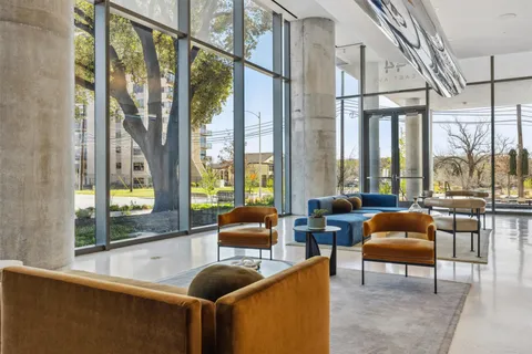 a living room with furniture and floor to ceiling windows