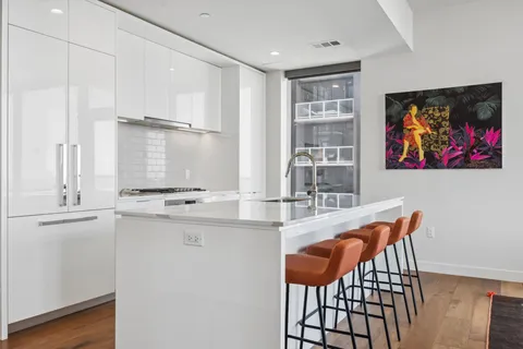 a kitchen with stainless steel appliances kitchen island a table and chairs in it