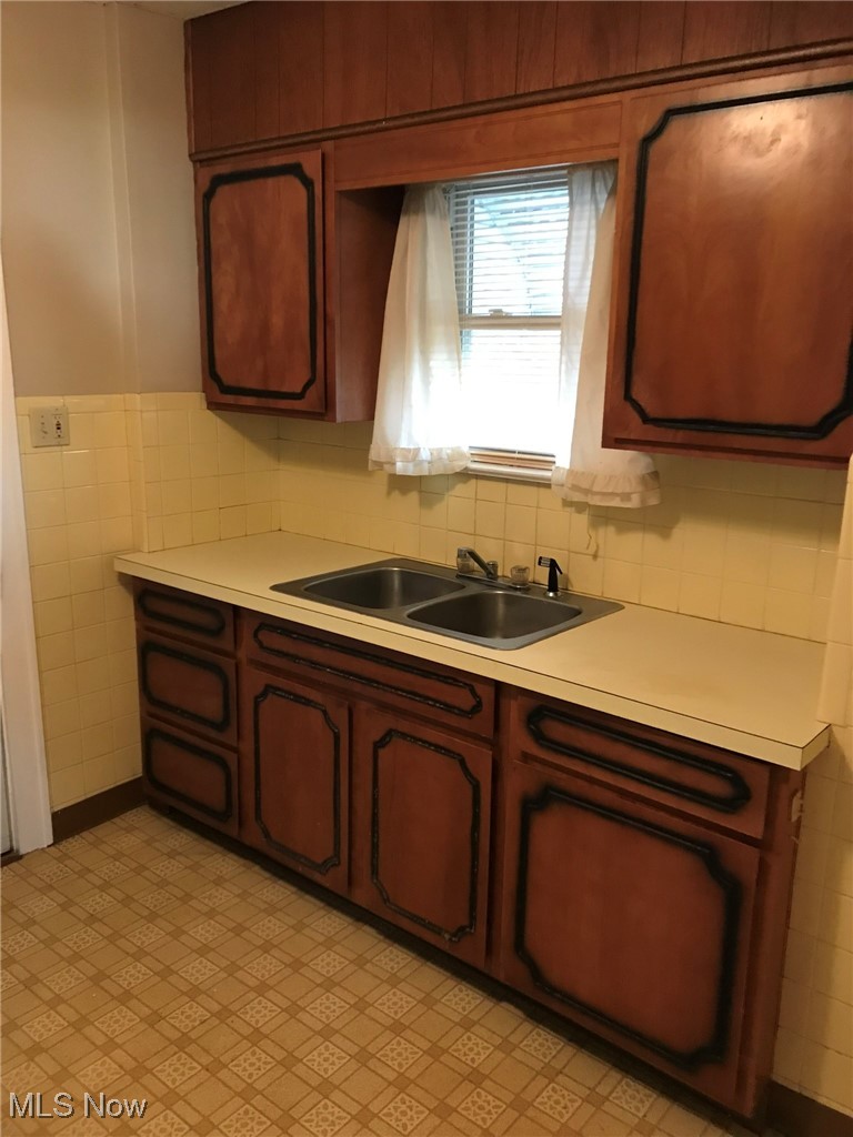 720 Kipling Street Akron, OH 44306 - Photo 6 of 21 Kitchen featuring wainscoting, tile walls, light floors, light countertops, and a sink