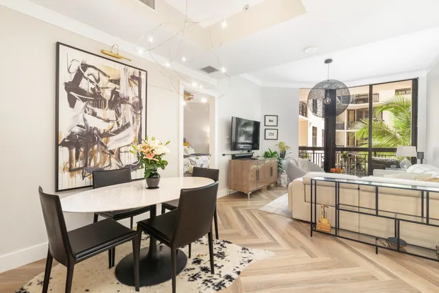 a living room with furniture a chandelier and a dining table