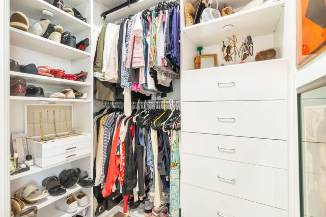 a view of walk in closet with clothes and shoes