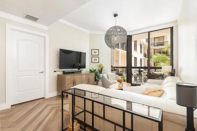 a living room with furniture a flat screen tv and a large window