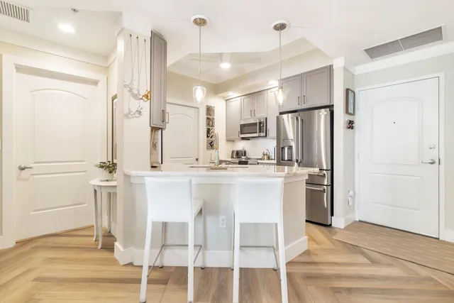 a kitchen with stainless steel appliances a refrigerator and wooden floor