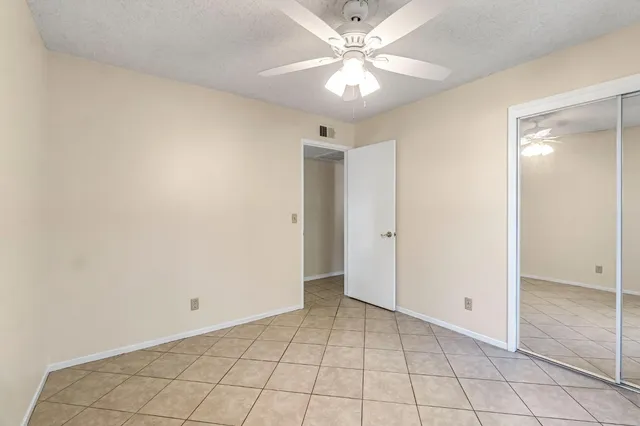 an empty room with windows and fan