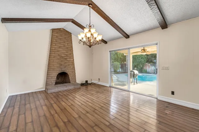 a view of a livingroom with wooden floor and chandelier