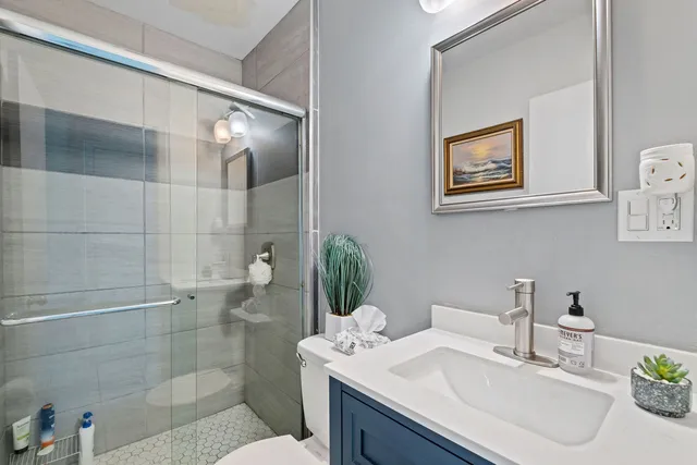 a bathroom with a sink a toilet and shower