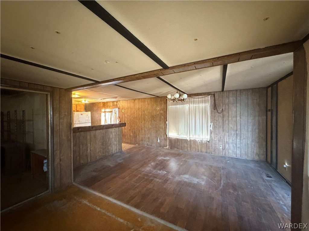 1666 Talc Road Bullhead City, AZ 86442 - Photo 10 of 61 Open concept living area featuring wood-finish paneling, wood-finish flooring, and exposed ceiling beams