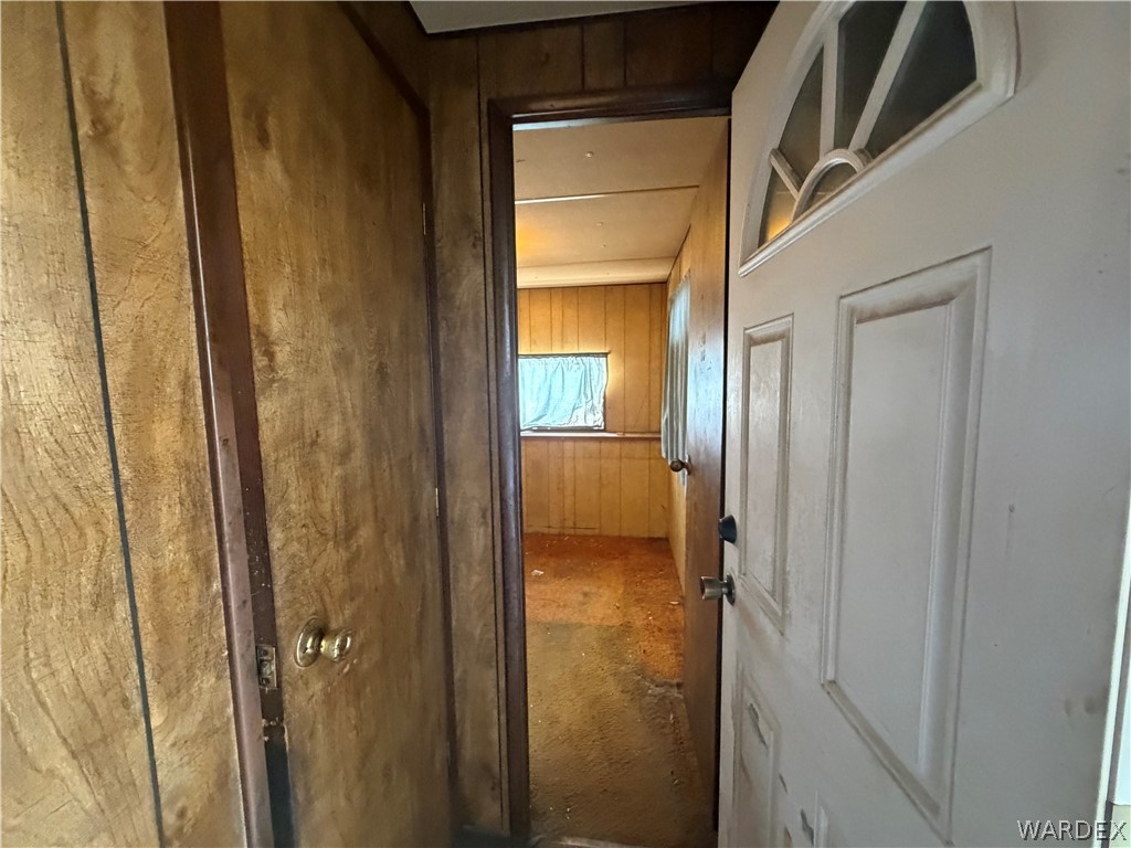 1666 Talc Road Bullhead City, AZ 86442 - Photo 29 of 61 Entryway featuring a paneled door with an arched transom window, wood-finish wall paneling, and an interior room with a window
