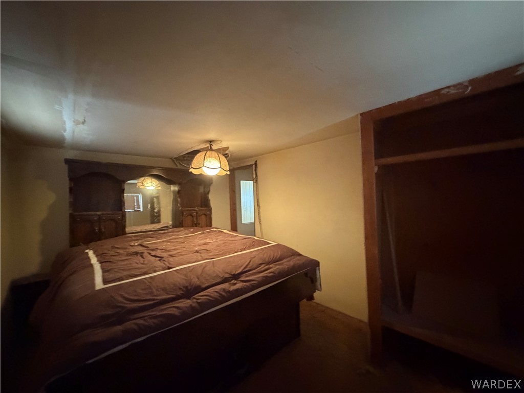 1666 Talc Road Bullhead City, AZ 86442 - Photo 34 of 61 Bedroom featuring a ceiling-mounted light fixture, built-in wall cabinetry, and an open wall niche