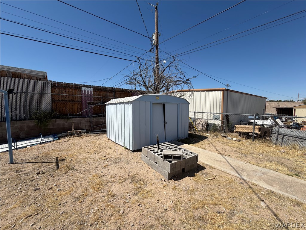 1666 Talc Road Bullhead City, AZ 86442 - Photo 41 of 61 Rear yard featuring a metal storage shed and concrete block hardscaping