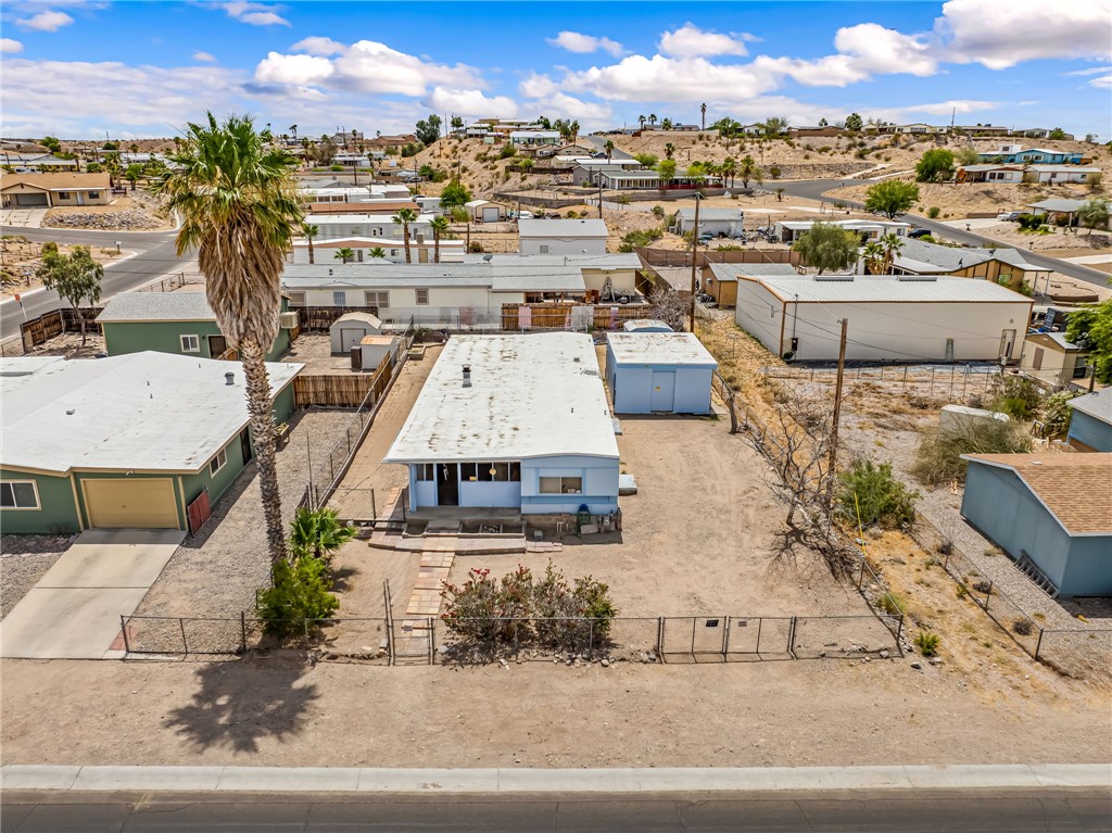 1666 Talc Road Bullhead City, AZ 86442 - Photo 48 of 61 Single-story residence featuring a light blue exterior, white roof, and a large front yard