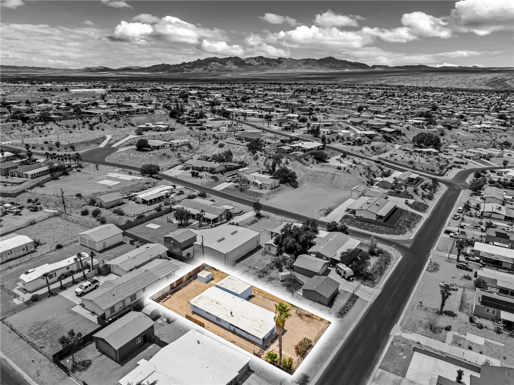 1666 Talc Road Bullhead City, AZ 86442 - Photo 57 of 61 Aerial perspective showcasing a property with a flat roofline, an unlandscaped yard, and established palm trees