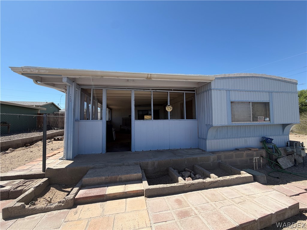 1666 Talc Road Bullhead City, AZ 86442 - Photo 6 of 61 Enclosed front patio featuring multiple windows, a tile patio, and a concrete pathway