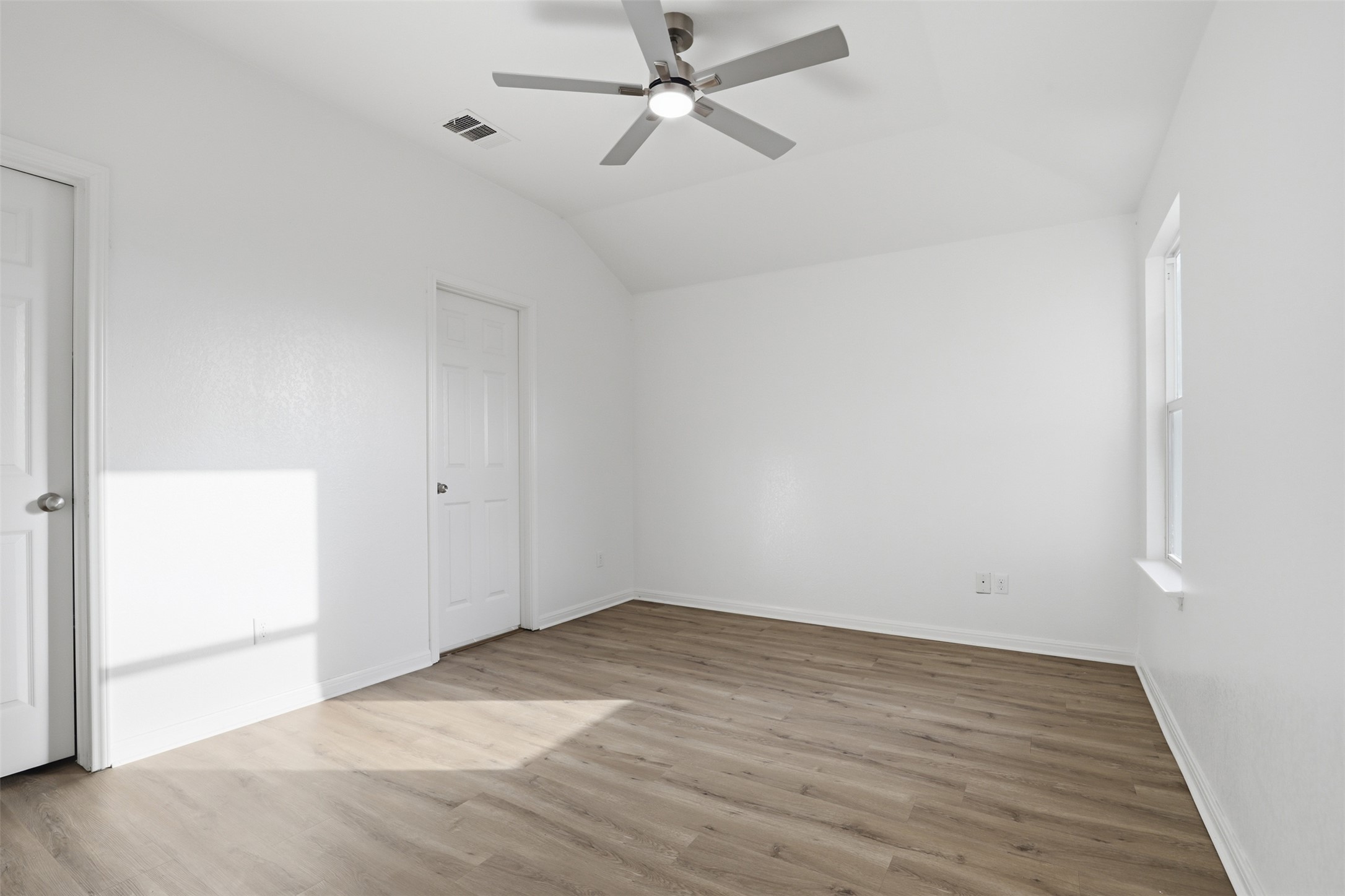 448 Nottingham Loop Kyle, TX 78640 - Photo 7 of 16 Room featuring wood-finish flooring, a contemporary ceiling fan with integrated lighting, and a vaulted ceiling