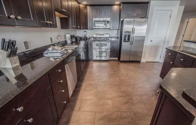 a kitchen with stainless steel appliances a sink stove and refrigerator