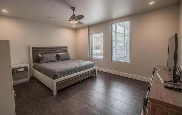 a bedroom with a bed and a flat tv screen on the dresser