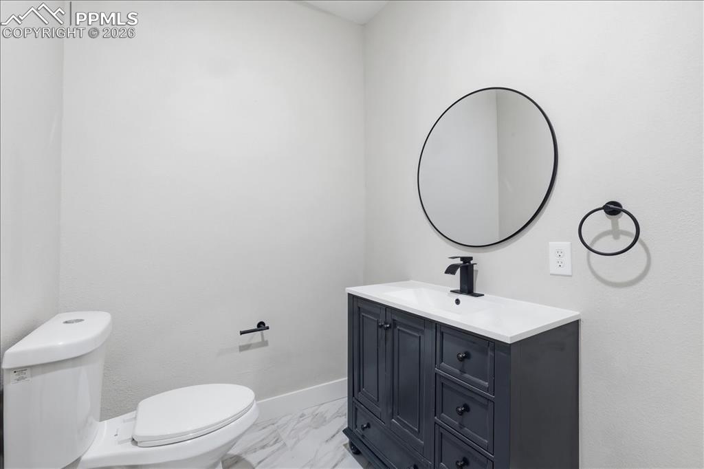 15755 Fool's Gold Lane Colorado Springs, CO 80921 - Photo 41 of 50 a bathroom with a toilet sink and mirror