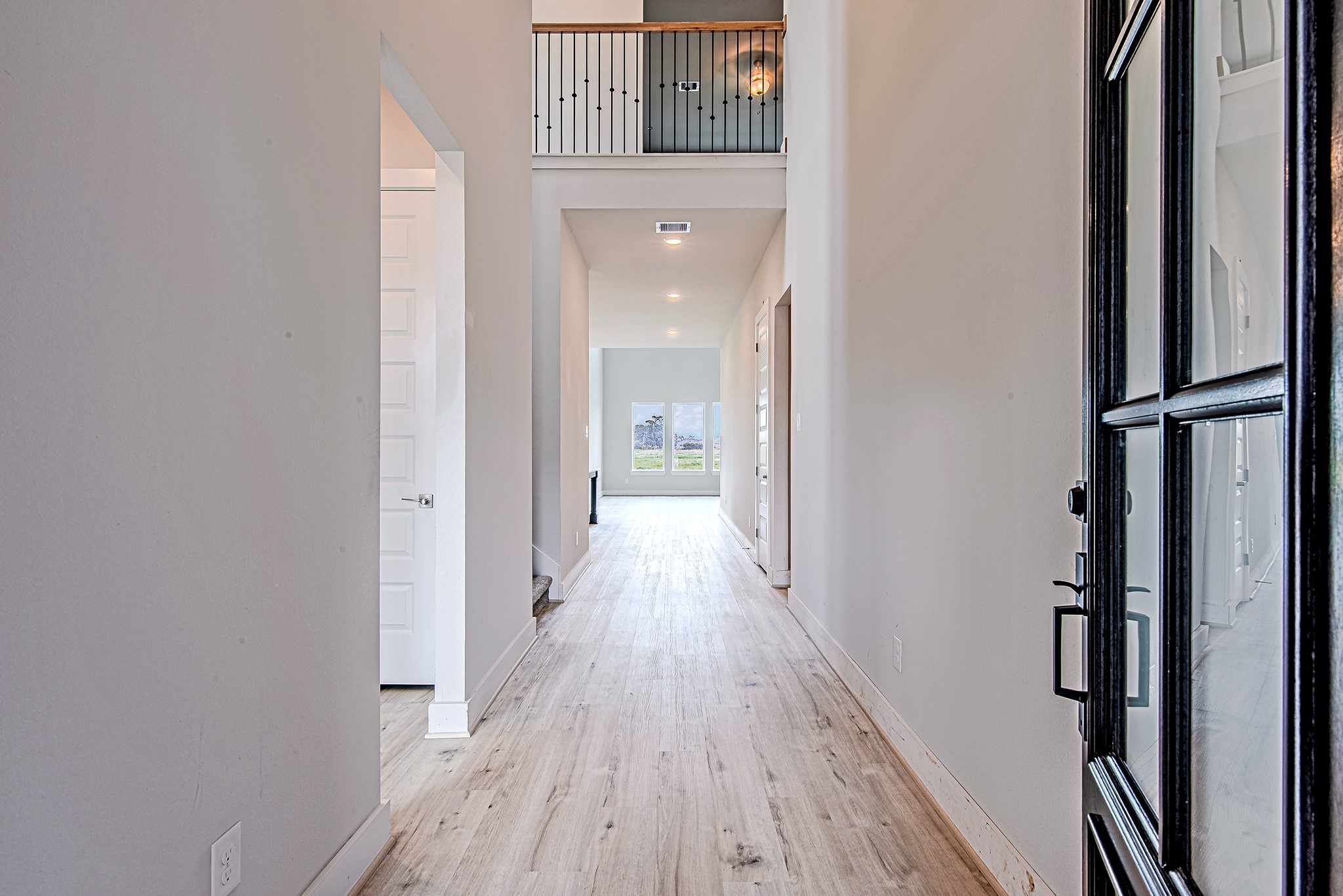 177 Peninsula Point Drive Montgomery, TX 77356 - Photo 6 of 40 Step into a bright and airy foyer with soaring ceilings, warm-toned floors, and a straight sightline to the light-filled living room beyond.