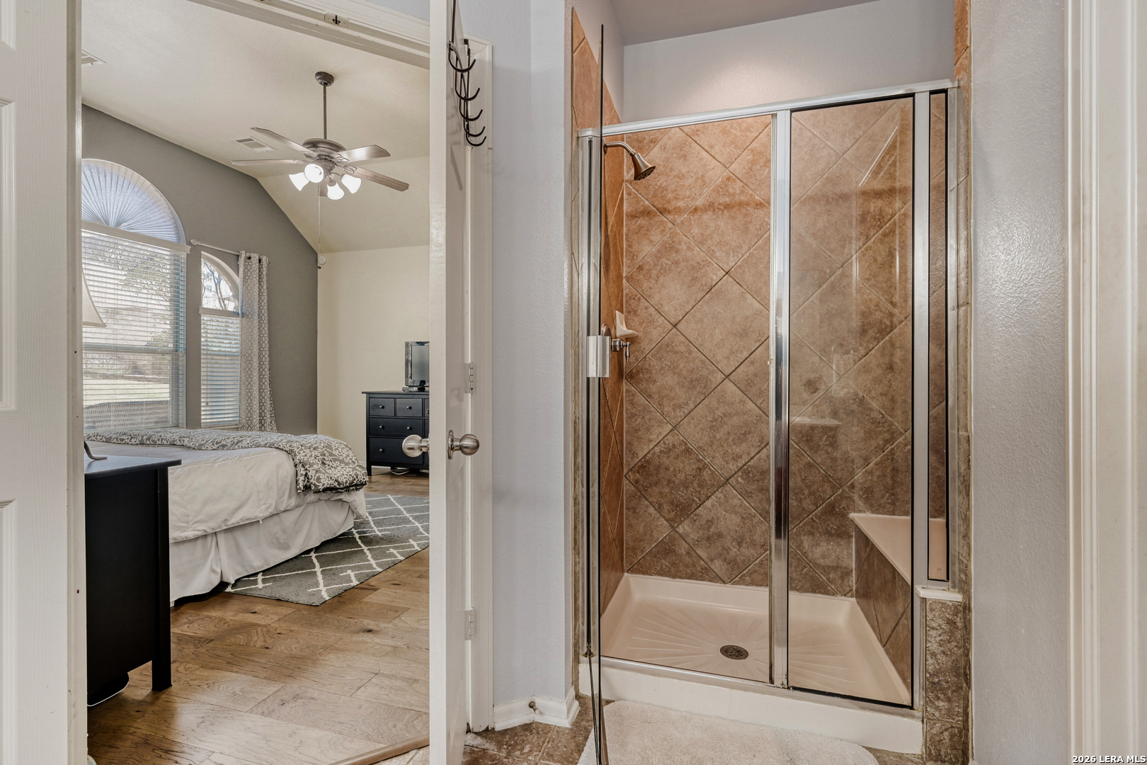 10539 Rainbow View Helotes, TX 78023 - Photo 14 of 24 a spacious bathroom with a glass shower door and a window