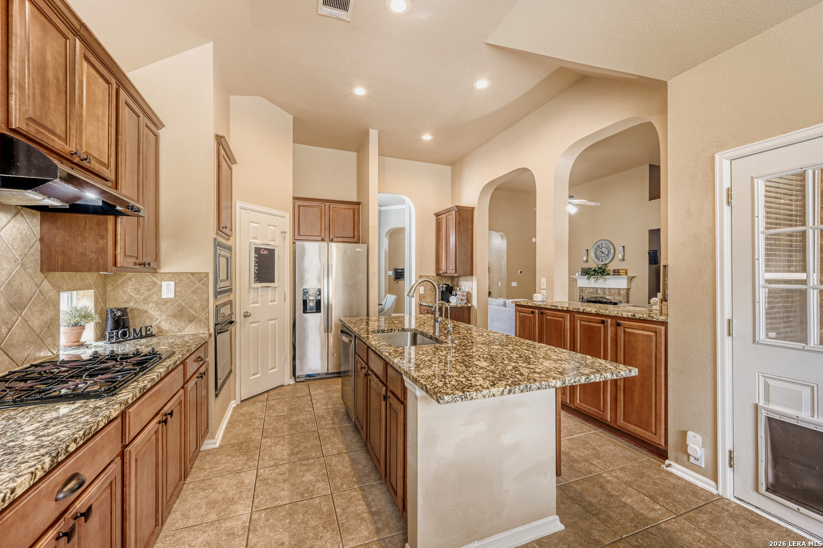 10539 Rainbow View Helotes, TX 78023 - Photo 8 of 24 a kitchen with stainless steel appliances granite countertop a stove oven and a refrigerator