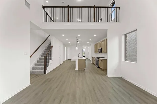 a view of staircase and kitchen with wooden floor