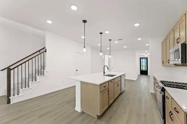 a kitchen with kitchen island a sink stove and wooden floor