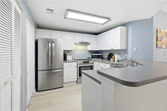 a kitchen with refrigerator cabinets and a sink
