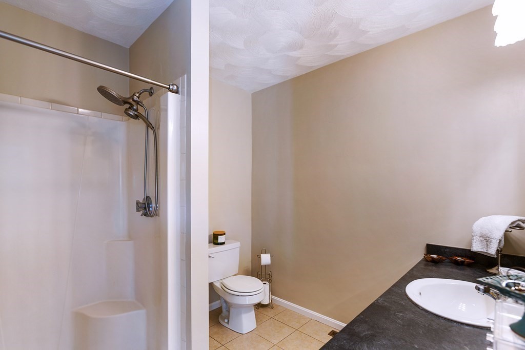 95 Lunenburg Road Townsend, MA 01474 - Photo 19 of 42 a bathroom with a granite countertop toilet a sink and a mirror
