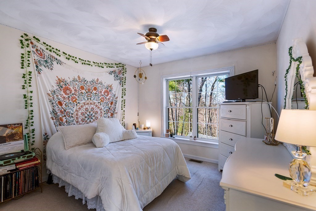 95 Lunenburg Road Townsend, MA 01474 - Photo 23 of 42 a bedroom with a bed a couch and a flat tv screen on the dresser