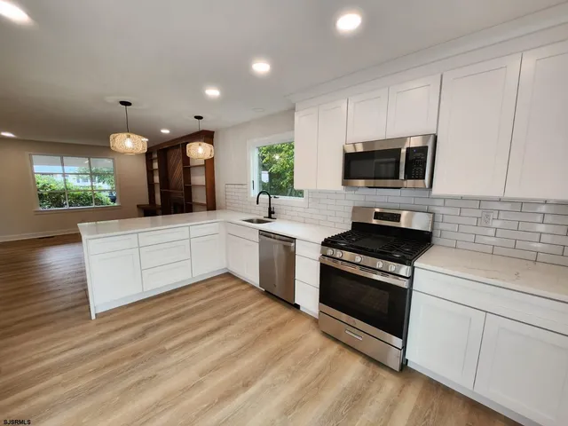 a kitchen with a stove a sink and a microwave