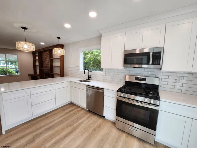 a view of a kitchen with a refrigerator and wooden floor