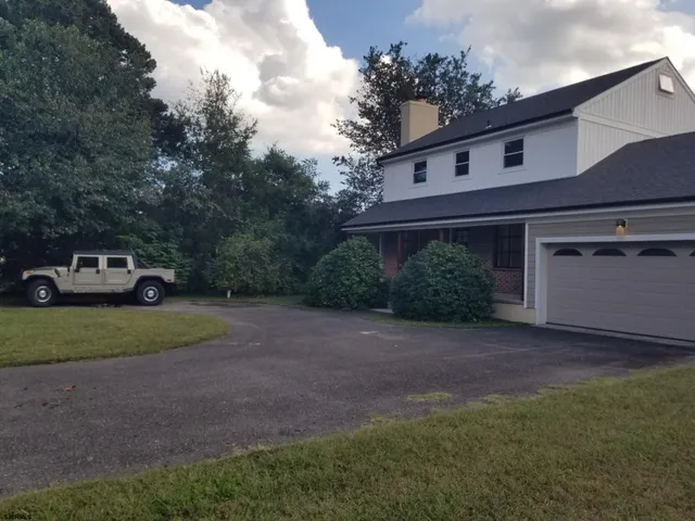 a car parked in front of a house with a yard