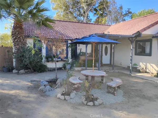 a view of a patio with a table and chairs under an umbrella