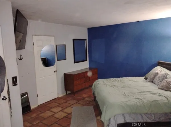 a bedroom with a bed and flat screen tv