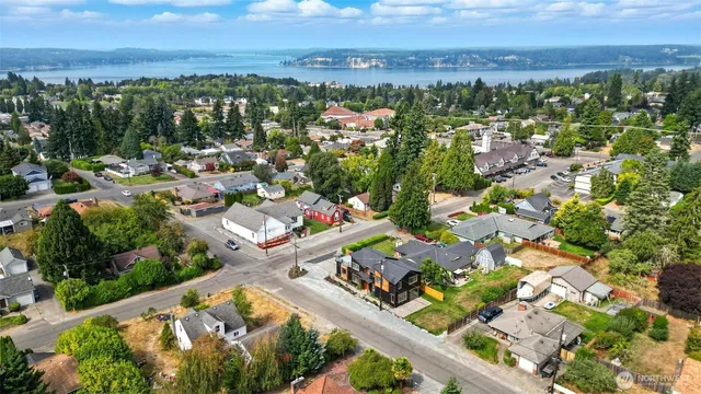 an aerial view of a city with lots of residential buildings ocean and mountain view in back