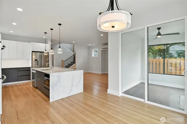 a kitchen with a sink a chandelier and wooden floor