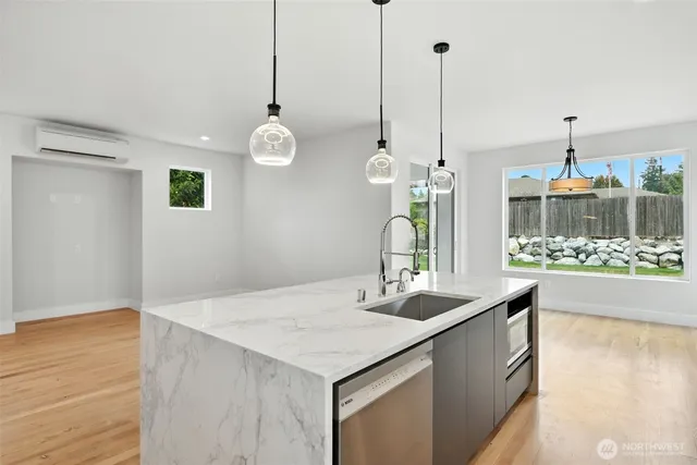 a large kitchen with kitchen island a large counter top space a sink stainless steel appliances and cabinets