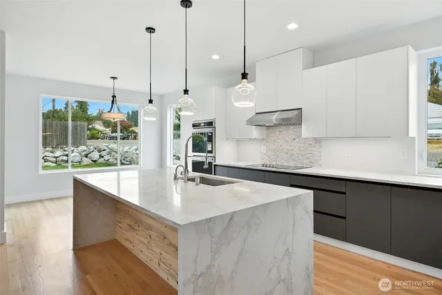 a large kitchen with kitchen island a sink stainless steel appliances and cabinets