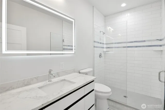 a bathroom with a shower sink and mirror