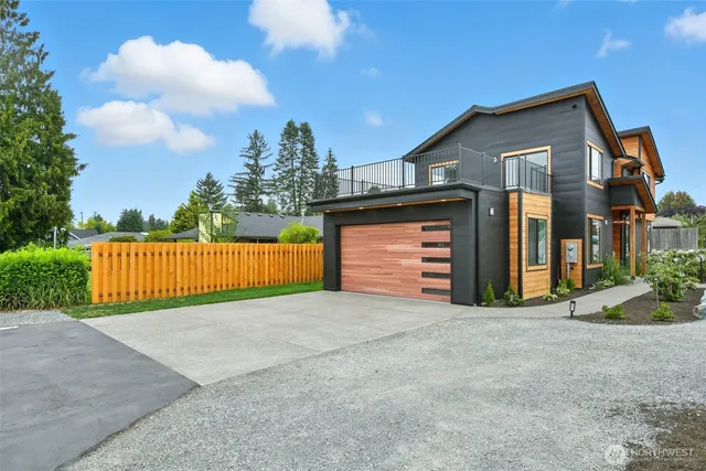 a view of house with backyard and bushes