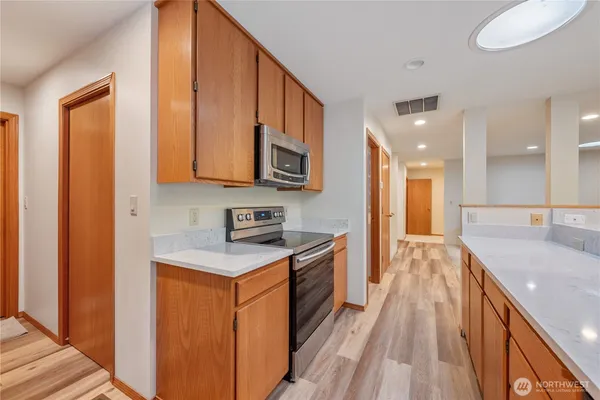 a kitchen with stainless steel appliances granite countertop a stove a sink and a refrigerator