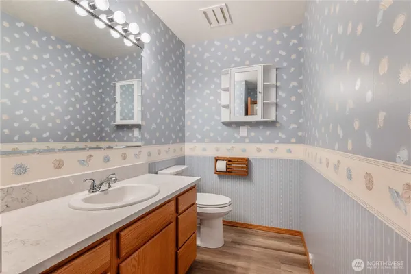 a bathroom with a sink a toilet and a mirror