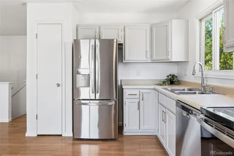 a kitchen with a refrigerator sink and cabinets