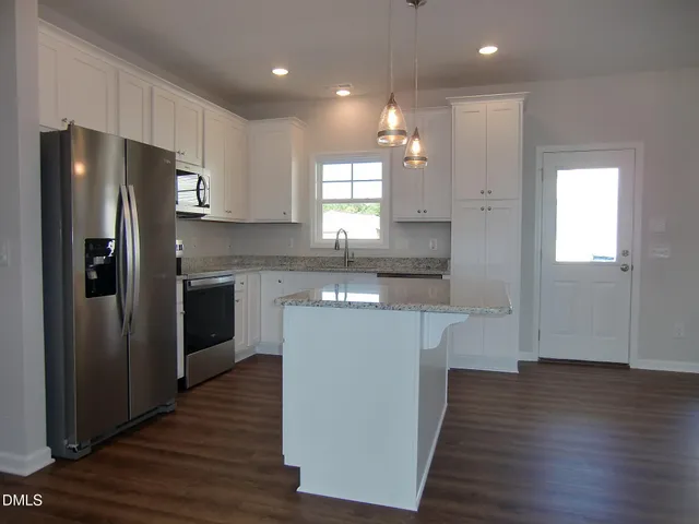 a kitchen with white cabinets and sink