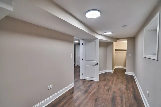 a view of empty room with wooden floor